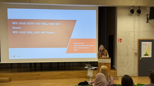 Ein Vortrag. Auf der Powerpoint-Folie steht "Wir sind nicht nur das, was wir lesen. Wir sind das, wie wir lesen."
