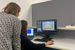 Zwei Personen schauen auf einen Monitor.