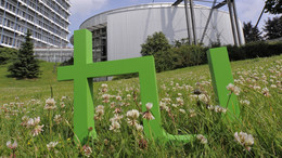 TU Dortmund Summer Festival Bild des Logos der TU Dortmund platziert auf einer Wiese zwischen Gebäuden der Universität.