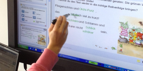 Kind schreibt auf einem Bildschirm