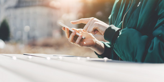  A person types in something on a smartphone
