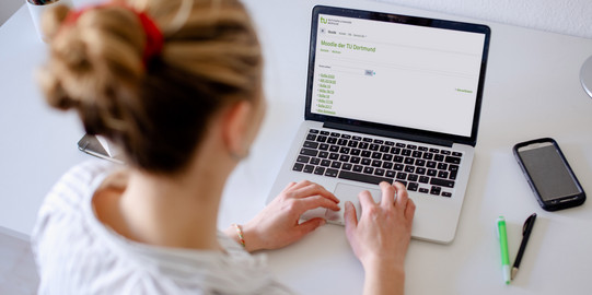 Photo of a woman looking at a laptop