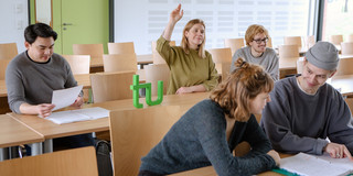 Studierende sitzen im Seminarraum und beteiligen sich am Seminar.